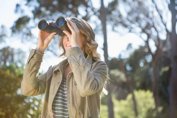 Woman using binoculars — Stock Photo, Image