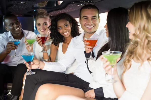 Des gens bien habillés qui boivent des cocktails dans une limousine — Photo