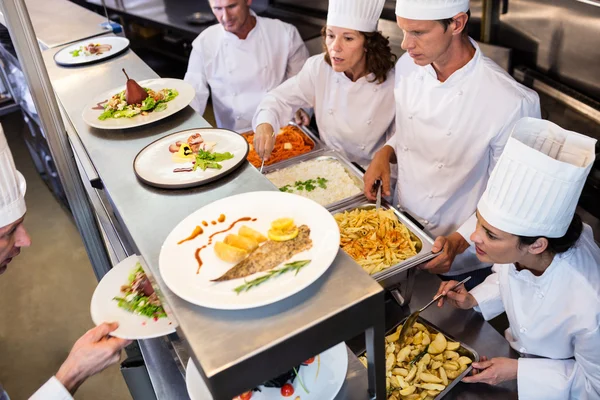 Chef-koks overhandigen diner borden — Stockfoto