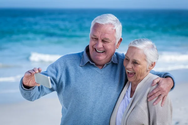 Söt äldre par med selfie på stranden — Stockfoto
