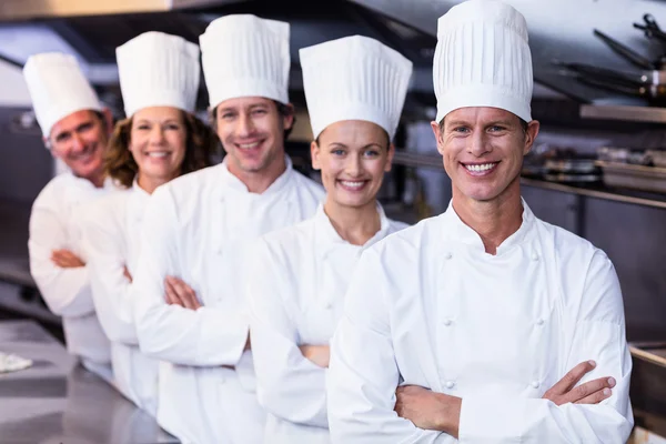 Equipo de chefs de pie en la cocina comercial — Foto de Stock
