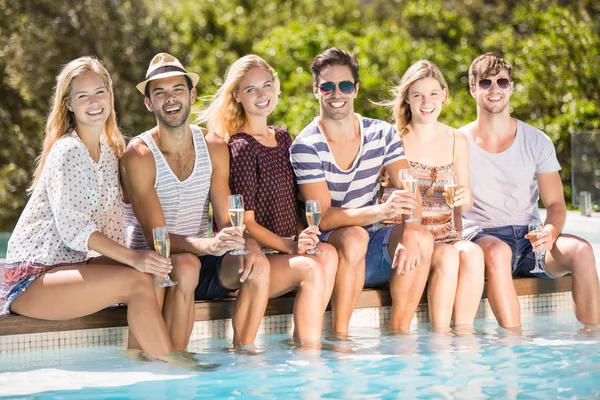 群的朋友坐在池畔瓶香槟 — 图库照片