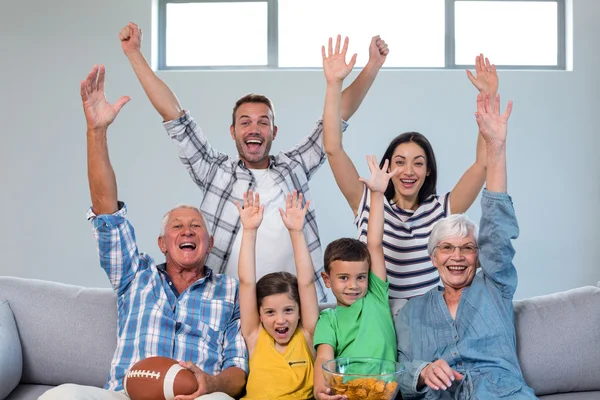 Lycklig familj tittar på en fotbollsmatch hemma — Stockfoto