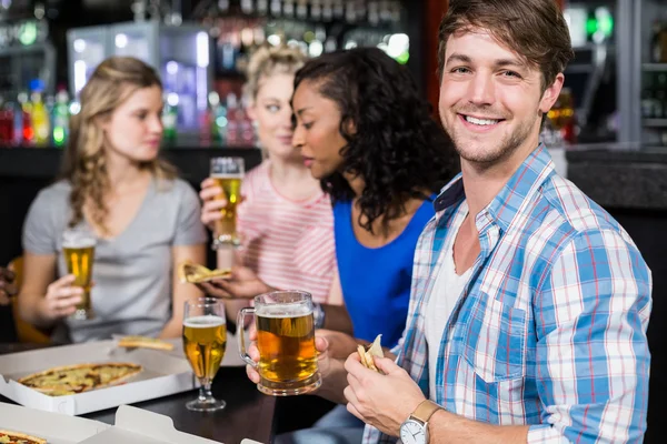 Amigos felices tomando una copa y pizza — Foto de Stock