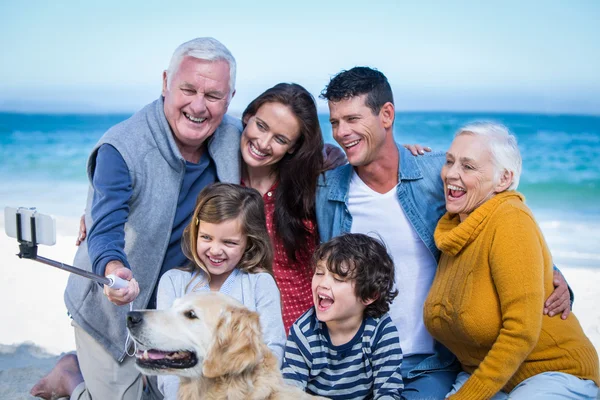 Família feliz com seu cão tirando uma selfie — Fotografia de Stock