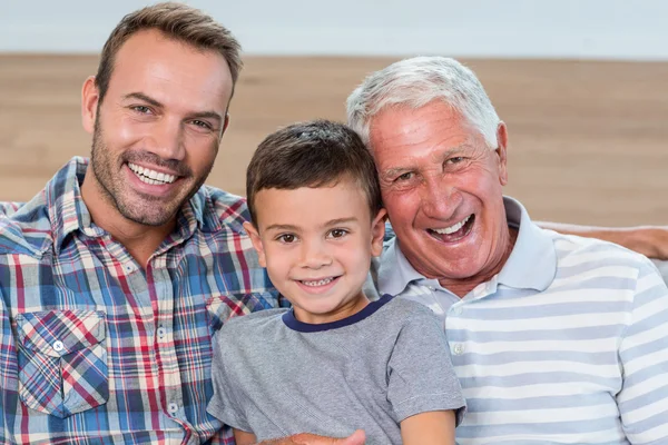 Отец, сын и внук сидят на диване — стоковое фото