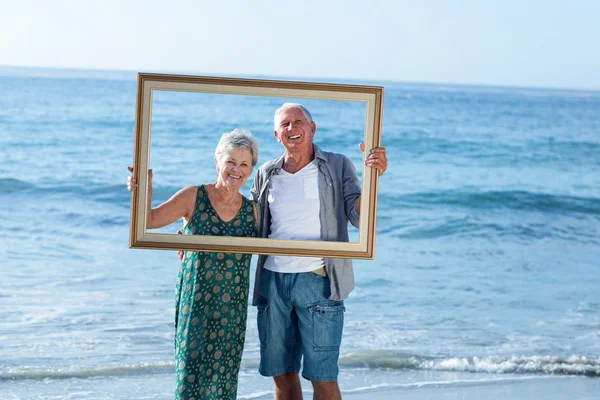 Senior paar posiert mit einem Rahmen — Stockfoto