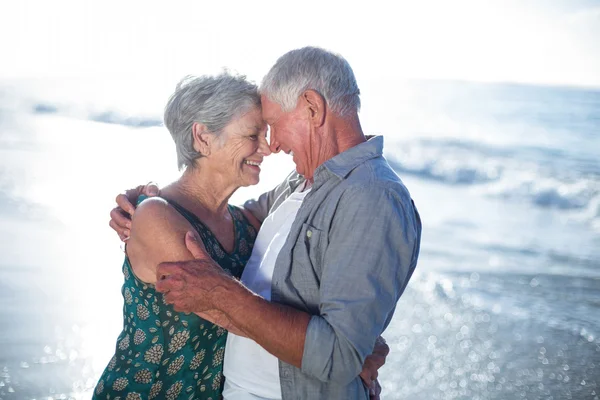 Starší pár objímat na pláži — Stock fotografie