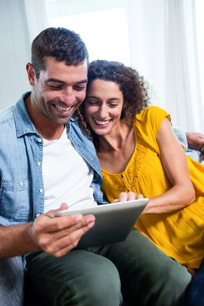 Jeune couple utilisant une tablette numérique sur canapé — Photo