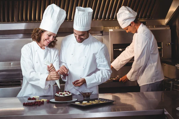 Chefs décorant un gâteau qu'ils viennent de faire — Photo