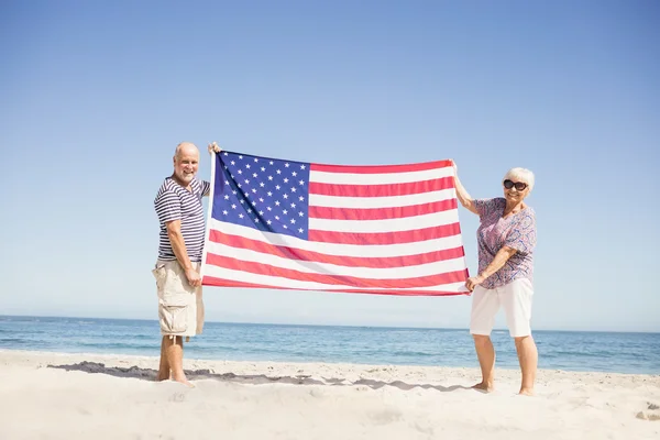 Pareja mayor sosteniendo bandera americana junta — Foto de Stock