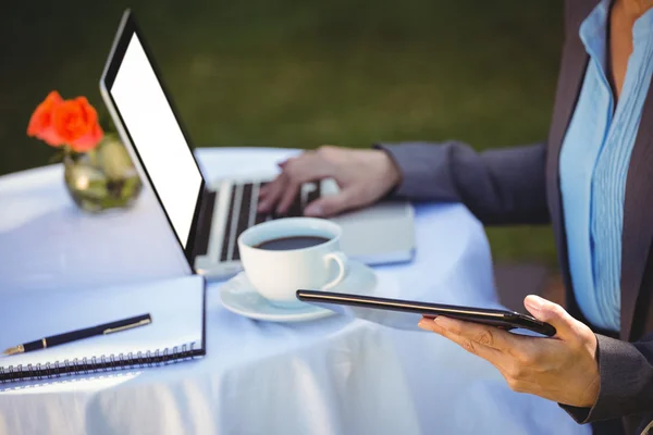 Empresária usando tablet com café — Fotografia de Stock