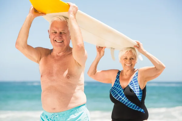 Senior paar dragende surfplank — Stockfoto