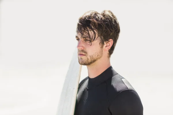 Hombre sosteniendo tabla de surf en la playa —  Fotos de Stock