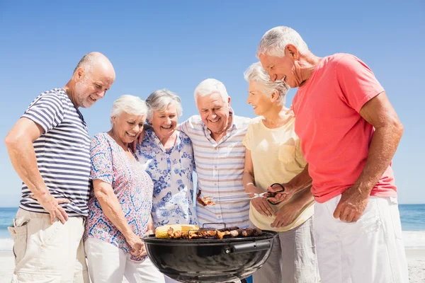 Amigos seniores fazendo um churrasco — Fotografia de Stock