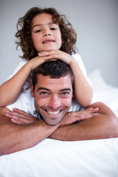 Filho deitado em pais de volta — Fotografia de Stock