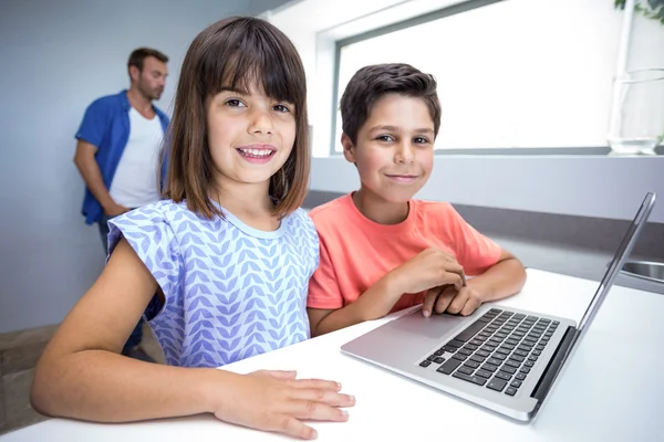 Gelukkige jongen en meisje met laptop — Stockfoto