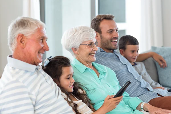 Happy family sitting on sofa — Stock Photo, Image