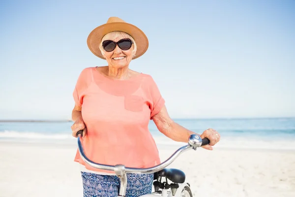 Lachende senior vrouw met haar fiets — Stockfoto