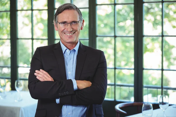 Smiling businessman posing with crossed arms — Stock Photo, Image