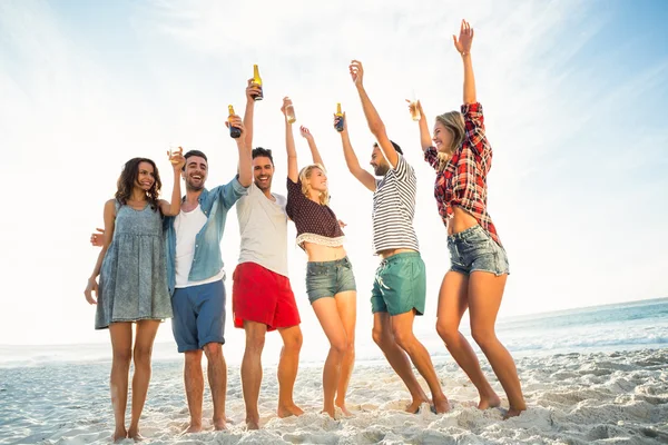 Freunde stoßen am Strand an — Stockfoto