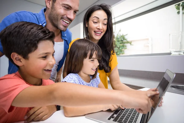 Familia feliz interactuando con el ordenador portátil — Foto de Stock