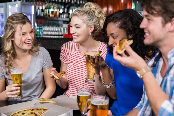 Amigos felices tomando una copa y pizza — Foto de Stock