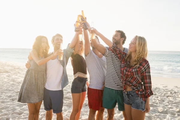 Glückliche Freunde, die Bierflaschen anheben — Stockfoto