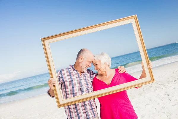 Sénior casal segurando quadro — Fotografia de Stock