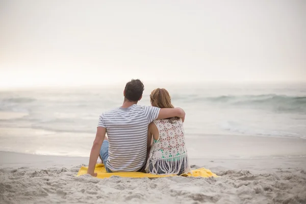 Visão traseira do casal sentado na praia — Fotografia de Stock