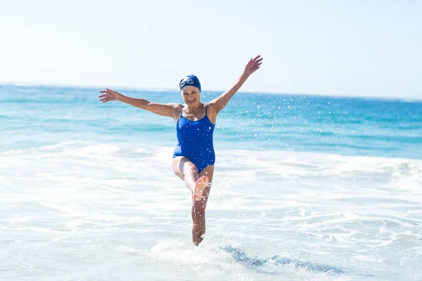 Mooie rijpe vrouw spelen op het strand — Stockfoto