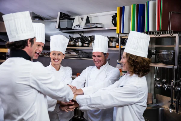 Chefs poniendo manos juntas y vitoreando — Foto de Stock