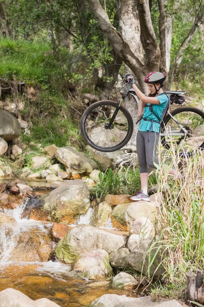 Frau trägt ihr Fahrrad — Stockfoto