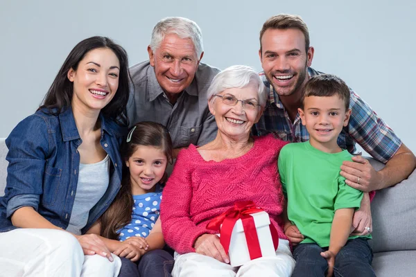 Family giving a gift to grandmother — Stock Photo, Image
