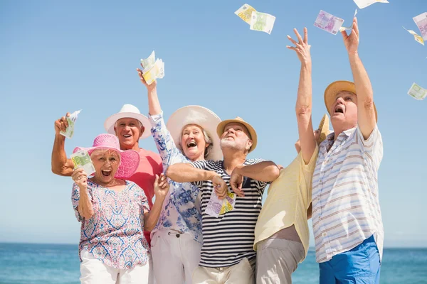 Ältere Freunde werfen mit Geld — Stockfoto