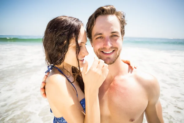 Pareja joven abrazándose en la playa — Foto de Stock