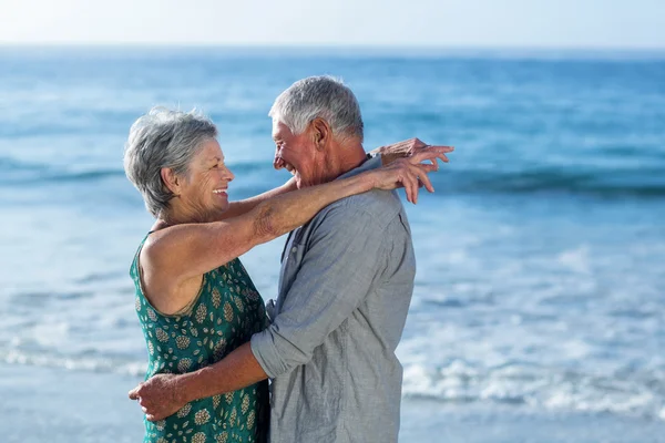 Casal sênior abraçando na praia — Fotografia de Stock