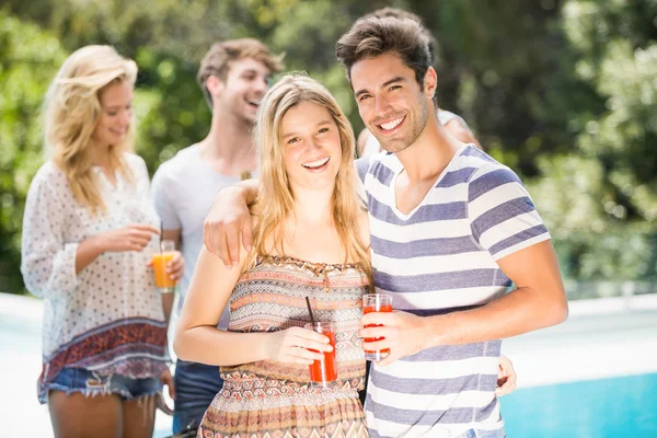 Young couple smiling and having juice together — Stock Photo, Image