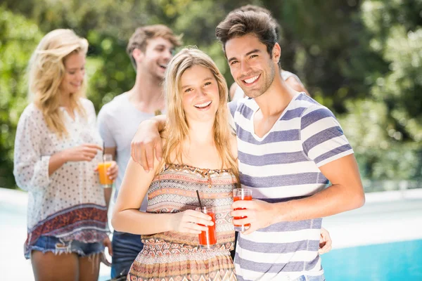 Casal jovem sorrindo e tomando suco juntos — Fotografia de Stock