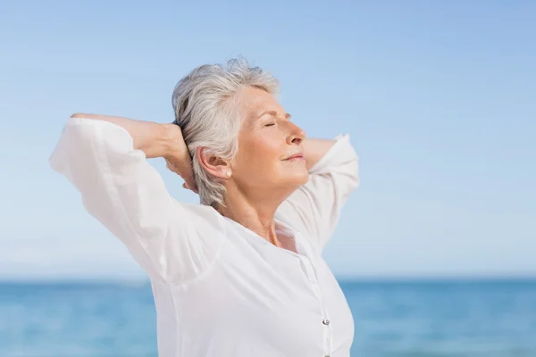 Senior mulher relaxante na praia — Fotografia de Stock