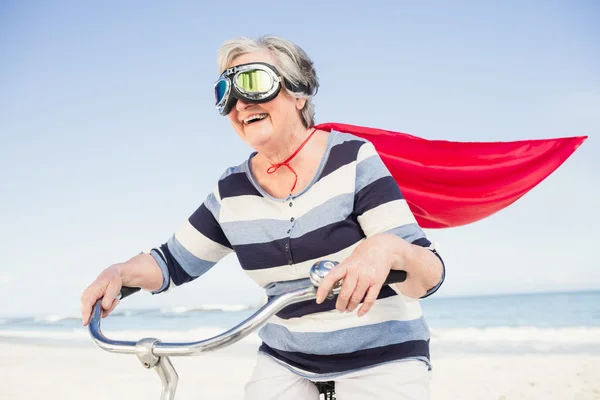 Senior superwoman on a bike — Stock Photo, Image