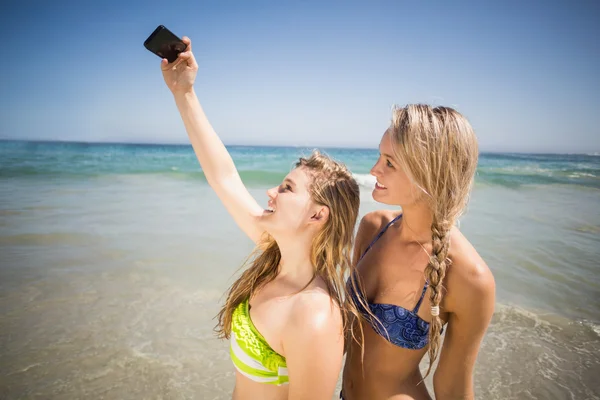 Två vänner i bikini med en selfie — Stockfoto