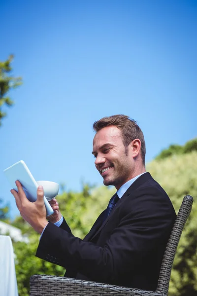 Empresario usando tableta y tomando un café — Foto de Stock