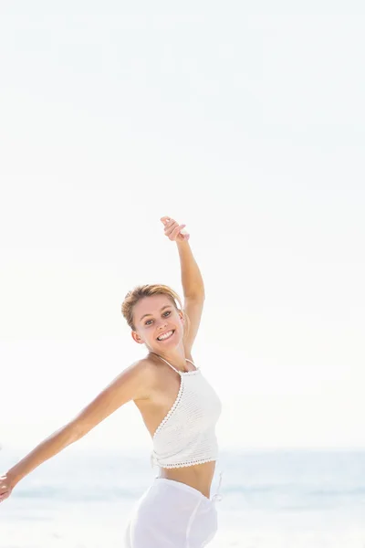 Porträt einer schönen Frau, die ihre Arme am Strand ausstreckt — Stockfoto