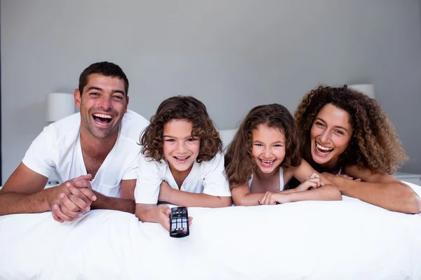 Portret van gelukkige familie liggend op bed — Stockfoto