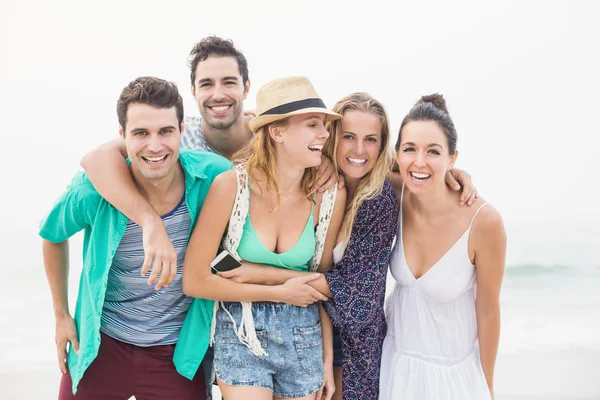 Grupp vänner står tillsammans på stranden — Stockfoto