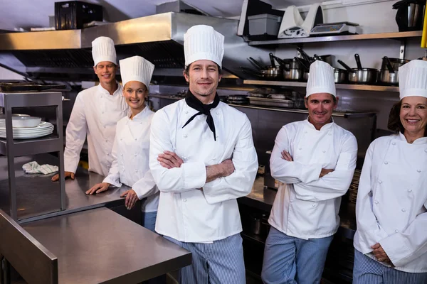 Команда шеф-кухарів стоїть на комерційній кухні — стокове фото