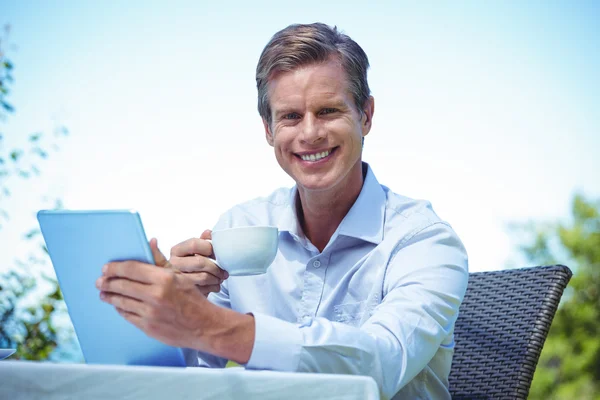 Бизнесмен с помощью планшета с кофе — стоковое фото