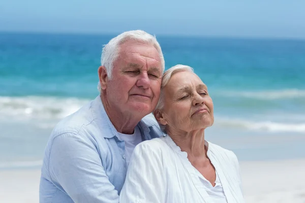 Seniorenpaar umarmt sich am Strand — Stockfoto