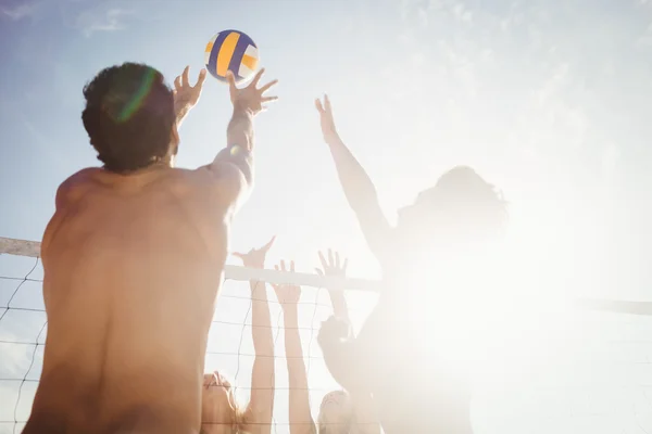 Друзі грають у пляжний волейбол — стокове фото